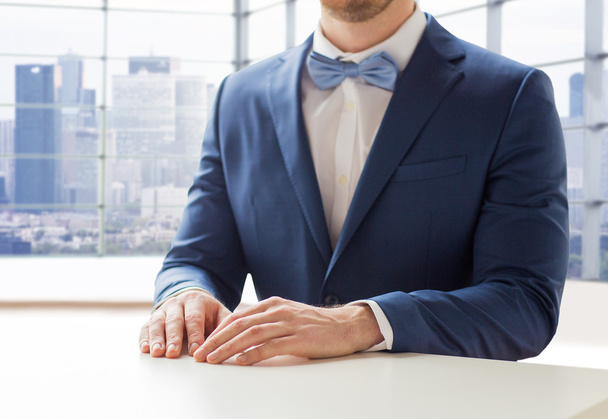 close up of man in suit and bow-tie at table - Foto, imagen