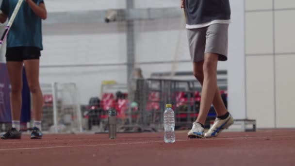 Due persone che camminano su una pista con una bottiglia d'acqua - Filmati, video