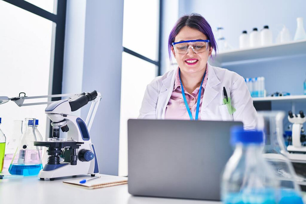 młody piękny plus rozmiar kobieta naukowiec uśmiecha pewny siebie za pomocą laptopa w laboratorium - Zdjęcie, obraz