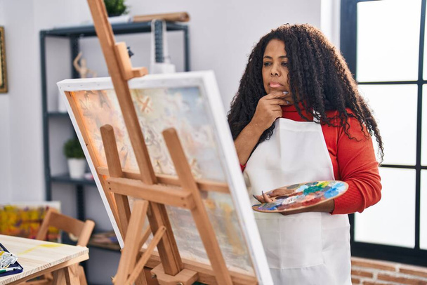 Afrikkalainen amerikkalainen nainen taiteilija etsii piirtää kanssa epäilystäkään ilme art studio - Valokuva, kuva