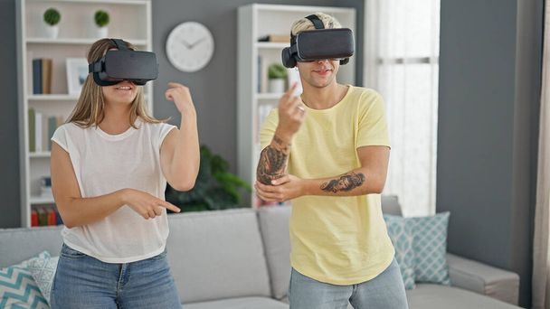 Schönes Paar spielt tanzendes Videospiel mit Virtual-Reality-Brille zuhause - Foto, Bild