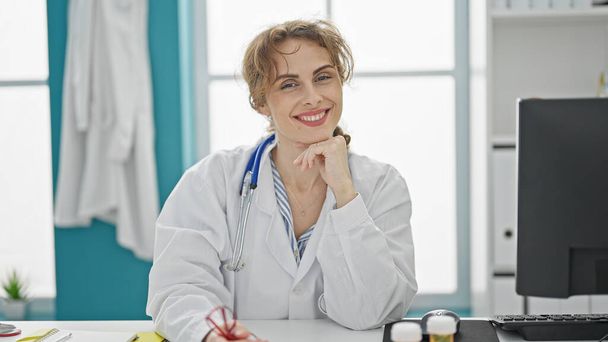 Молодая женщина-врач улыбается в клинике - Фото, изображение