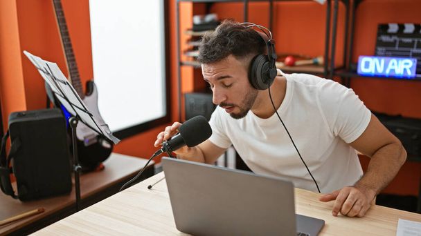 Νεαρός άραβας μουσικός δημοσιογράφος μιλώντας στο ραδιοφωνικό στούντιο εκπομπής - Φωτογραφία, εικόνα