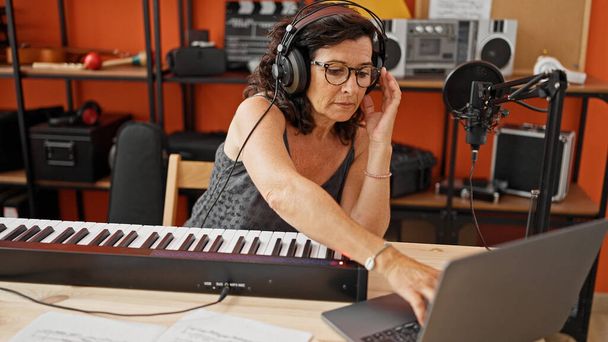 Medioevo musicista donna ispanica suonare il pianoforte avendo lezione online presso lo studio di musica - Foto, immagini