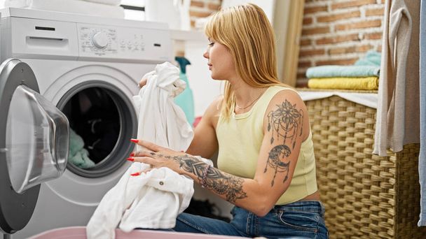 Νεαρή ξανθιά γυναίκα πλένει ρούχα στο πλυσταριό - Φωτογραφία, εικόνα