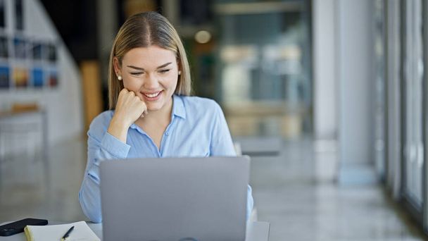 若いブロンドの女性のビジネス労働者を使用してノートパソコンオフィスで働く - 写真・画像