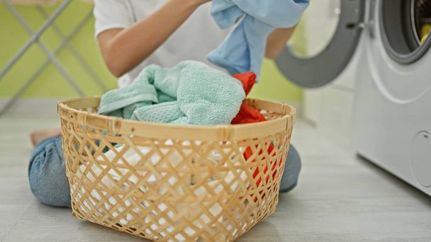 Young blonde woman washing clothes at laundry room - Photo, Image
