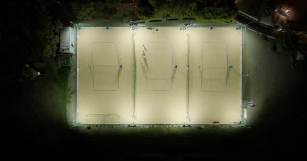 Playgrounds noturnos: Vistas aéreas da vida da cidade e jogos de voleibol de areia sob o céu noturno. Imagens 4k de alta qualidade - Filmagem, Vídeo