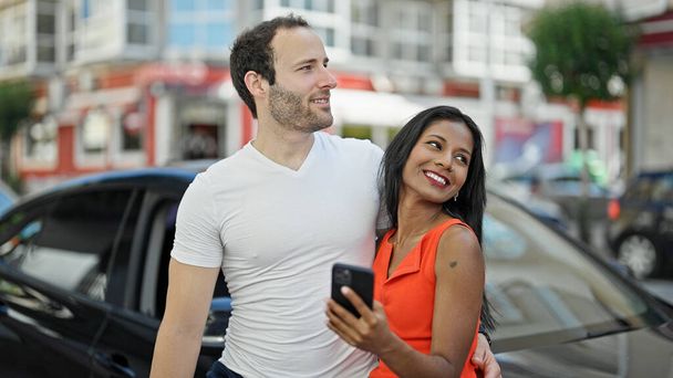 Kaunis pari älypuhelimella seisoo autolla kadulla - Valokuva, kuva