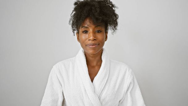 Afrikkalainen amerikkalainen nainen yllään kylpytakki seisoo vakavat kasvot yli eristetty valkoinen tausta - Valokuva, kuva