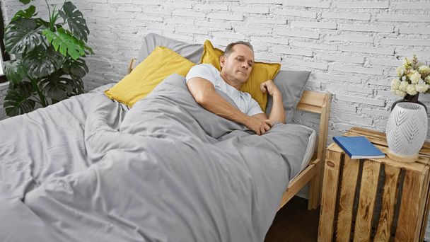 Middle age man lying on bed sleeping at bedroom - Photo, Image