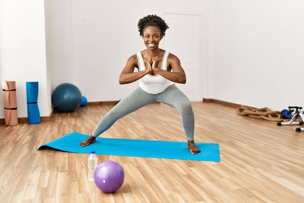 African american woman smiling confident training yoga at sport center - Photo, Image