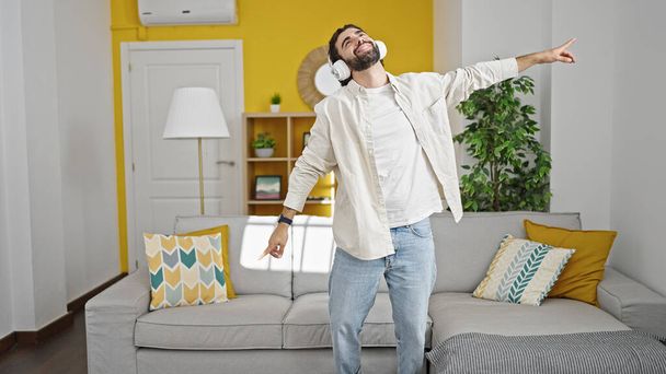 Fiatal spanyol férfi zenét hallgat otthon. - Fotó, kép