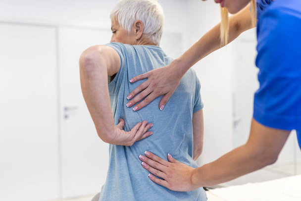 Seniorin mit chiropraktischer Rückenanpassung. Osteopathie, Alternativmedizin, Schmerzlinderungskonzept. Krankengymnastik, Rehabilitation von Verletzungen - Foto, Bild