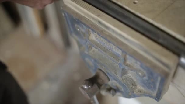 Mann klemmt Stahlrohr in Werkstatt-Schraubstock - Filmmaterial, Video