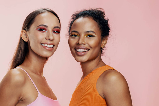 Piękno kobieta różowy makijaż razem połysk afrykański dwa body care mieszane amerykański oko zdrowa pielęgnacja skóra portret szczęśliwy atrakcyjny wyścig twarz dziewczyny studio model kaukaski kolorowe piękne - Zdjęcie, obraz