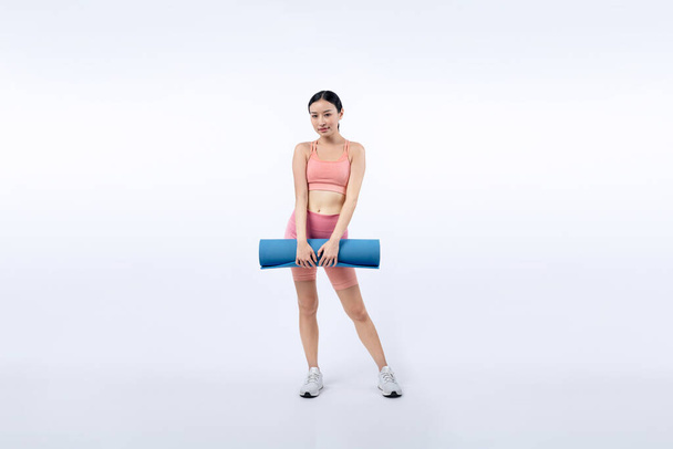 Jeune femme asiatique attrayant portrait en vêtements de sport avec tapis d'exercice. Exercice sain et routine d'entraînement concept de mode de vie. Studio a tourné en arrière-plan isolé. Vigoureux - Photo, image
