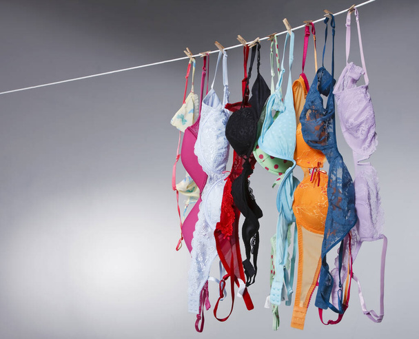 Ryhmä värikkäitä rintaliivejä roikkua vaatteet linja studiossa ympäristössä - Valokuva, kuva