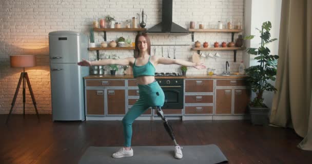 Bacak protezi olan bir kadın yoga yapıyor ve kendine güveni tam. Özürlü bir kadın yoga pratiğinde teselli ve denge buluyor. - Video, Çekim