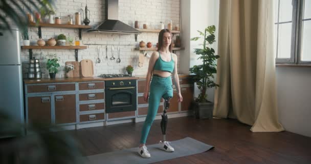 Frau mit Beinprothese führt Yoga-Pose aus, die Zuversicht ausstrahlt. Frau mit Behinderung findet Trost und Gleichgewicht in Yoga-Praxis, die innere Stärke zeigt - Filmmaterial, Video