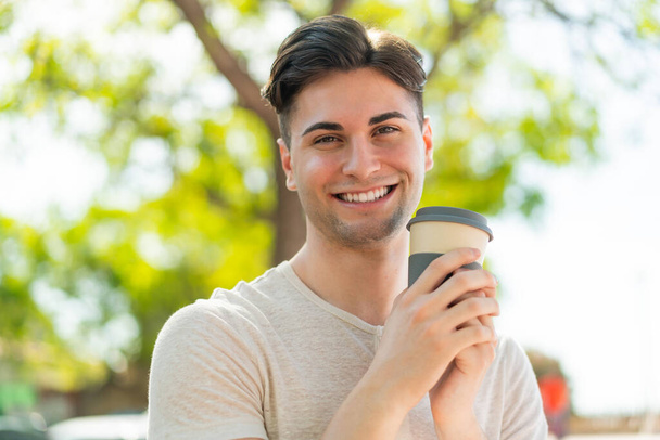若いですハンサムな男保持Aコーヒーとともに幸せな式 - 写真・画像