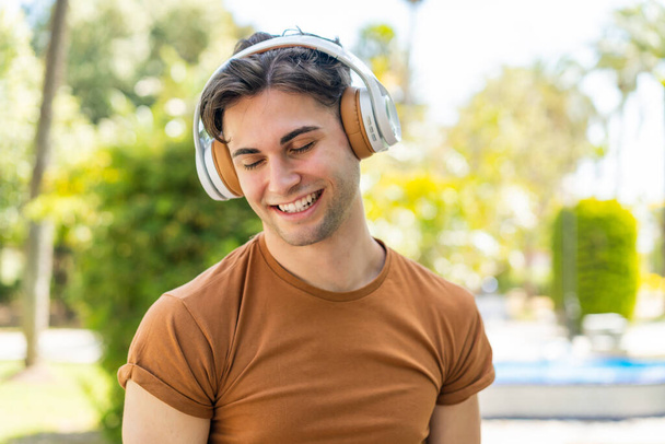 Joven hombre guapo escuchando música
 - Foto, imagen
