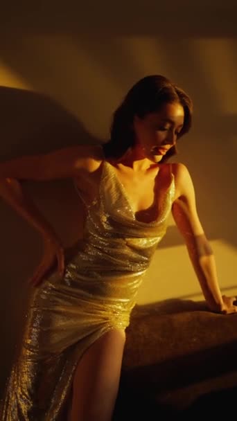 Πορτρέτο μιας νεαρής γυναίκας που στέκεται σέξι σε ένα δωμάτιο ξενοδοχείου με ένα γυαλιστερό φόρεμα. Λεπτή γυναίκα ποζάρει για την κάμερα. - Πλάνα, βίντεο