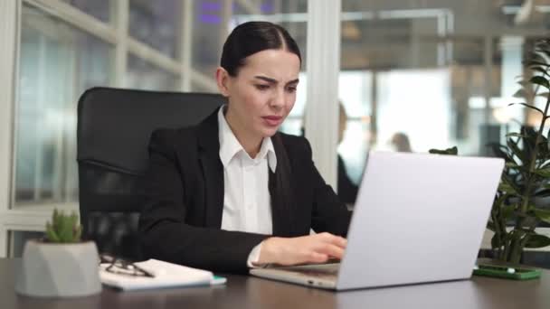 Ingerelt vállalati alkalmazott gépel a laptop billentyűzetén, miközben problémái vannak a munka időben történő befejezésével. Kaukázusi nő ül széken aggasztó és problémái vannak a határidők hivatalban. - Felvétel, videó