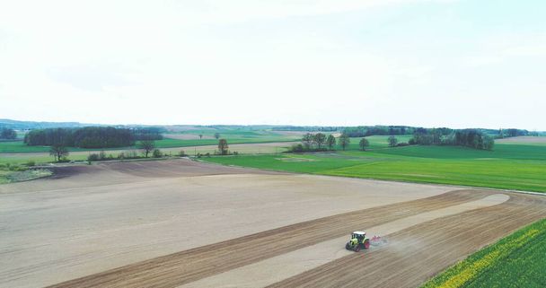 Prise de vue du tracteur travaillant sur le terrain. L'agriculteur laboure le champ avant de planter du blé. - Photo, image