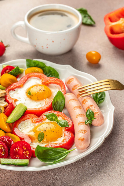 Frühstückswürste mit Spiegeleiern, Bratwürsten, Tomaten, Pilzen und Gemüse. vertikales Bild. Ansicht von oben. - Foto, Bild