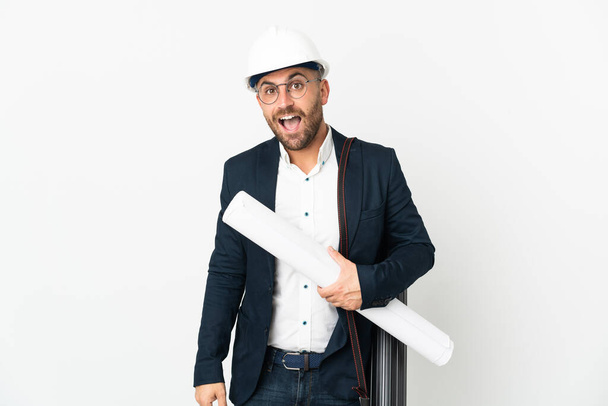Архітектор чоловік з шоломом і тримає креслення ізольовані на білому тлі з несподіваним виразом обличчя
 - Фото, зображення