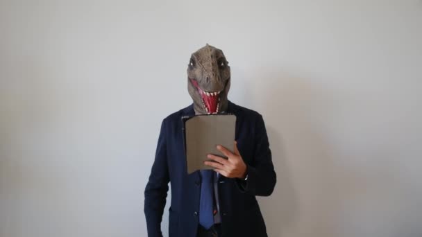 üzletember dinoszaurusz maszk tartja tabletta pc beltéri - Felvétel, videó