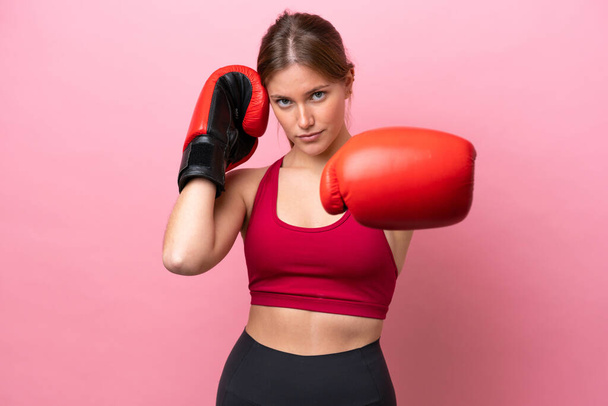 Young caucasian woman isolated on pink background with boxing gloves - Photo, Image