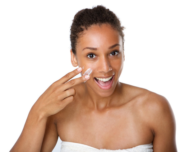 Sonriente mujer afroamericana aplicando loción en la piel
 - Foto, Imagen