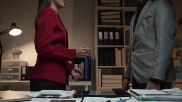 Twee onherkenbare zakenmensen schudden elkaar de hand in een kantoor Twee Aziatische zakenmensen komen overeen om een baan aan te bieden aan een vrouwelijke kandidaat na afloop van het interview. - Video