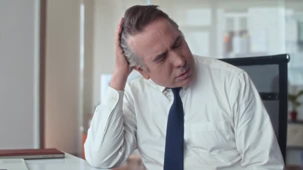 Colpo medio di imprenditore invecchiato esausto che soffre di mal di testa durante gli straordinari in ufficio - Filmati, video