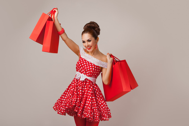 Happy Woman Holding Up Shopping Bags. Pin-up retro style. - Foto, Imagen