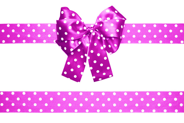 lint met witte polka dots gemaakt van zijde en roze boog - Foto, afbeelding