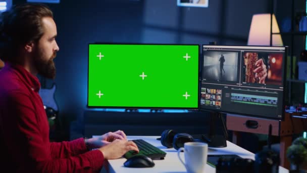 Videografo utilizza il software di editing sul computer schermo verde per assemblare filmati in risultato finale coerente. Clip di correzione del colore esperti sul monitor mockup per garantire che il progetto soddisfi l'estetica desiderata - Filmati, video