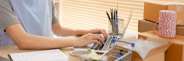 Online-Verkauf, Junge Frau benutzt Laptop, um mit einem Kunden zu tippen und zu chatten, Produkte online versenden, Work-from-Home KMU-Inhaber gedeiht im Online-Verkauf, Verpackungsbox. - Foto, Bild