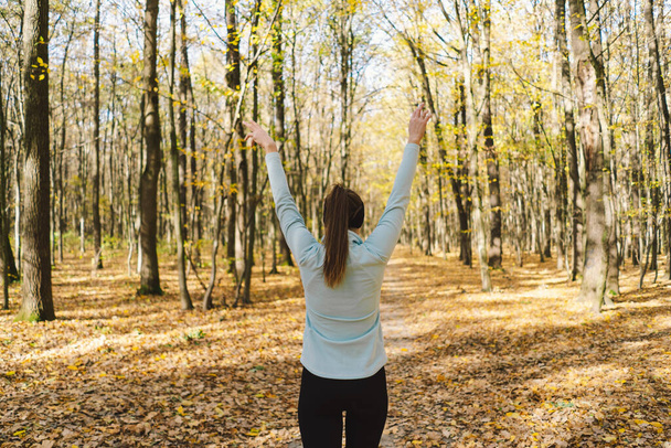 Menina bonita fazendo fitness na natureza em uma floresta de outono ensolarada. Corpo positivo, esportes para mulheres, harmonia, estilo de vida saudável, amor próprio e bem-estar. - Foto, Imagem