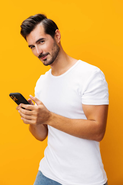 Man cyberspace technology space lifestyle surprise happy business mobile toothy smartphone copy studio phone eyeglass phone smiling message pointing yellow smile communication portrait - Photo, Image