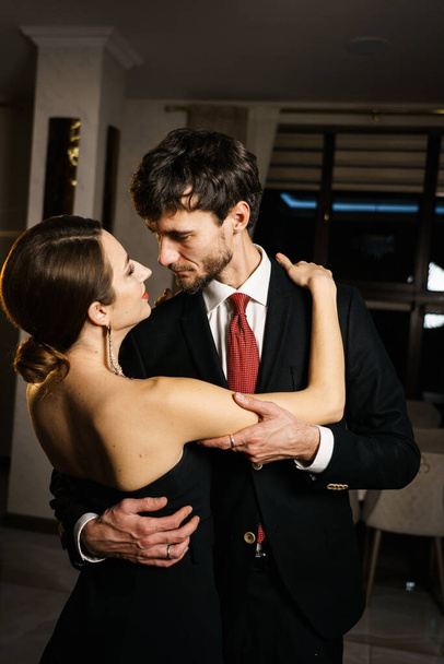 Egy elegáns férfi és nő estélyi ruhában, öltönyben és ruhában, pózolva egy fényűző hotel hátterében. Kaszinó - Fotó, kép