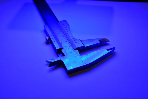 Оборудование калибра mesure весит микрометр и излучает синий свет. Высокое качество фото - Фото, изображение