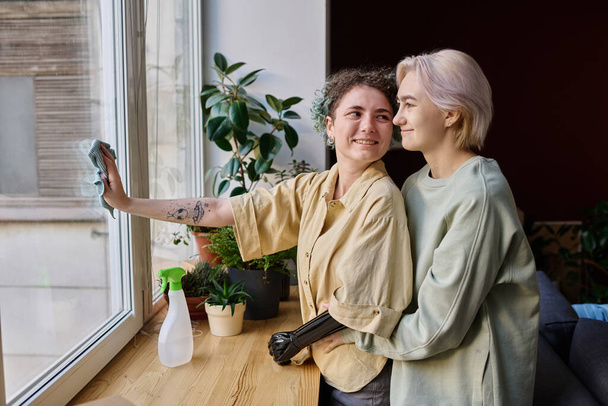 Lesbijki para robi prace domowe w domu, sprzątają razem okno - Zdjęcie, obraz