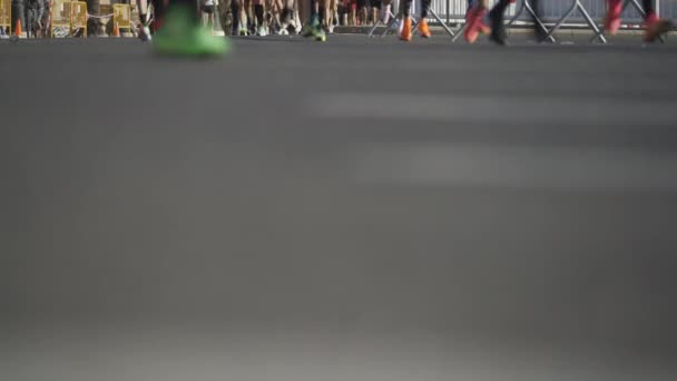 Biegacze rozmywają nogi podczas miejskiego maratonu na rozmazanej asfaltowej drodze. - Materiał filmowy, wideo