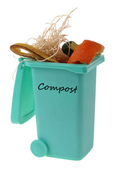 Concepto de compostaje con un bote de basura lleno de residuos orgánicos de cerca sobre fondo blanco - Foto, imagen