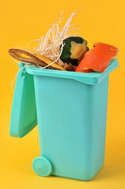 Concetto di compostaggio con bidone pieno di rifiuti organici primo piano su fondo giallo - Foto, immagini