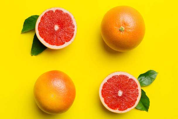 čerstvé ovoce grapefruit s šťavnatým grapefruitem plátky na barevném pozadí. Horní pohled. Rozumím. kreativní letní koncept. Polovina citrusů v minimálním bytě ležela s kopírovacím prostorem. - Fotografie, Obrázek