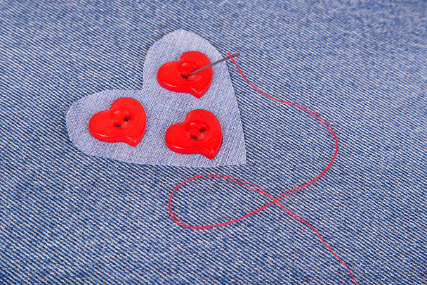 赤いハート形の針と赤い糸とボタン - 写真・画像